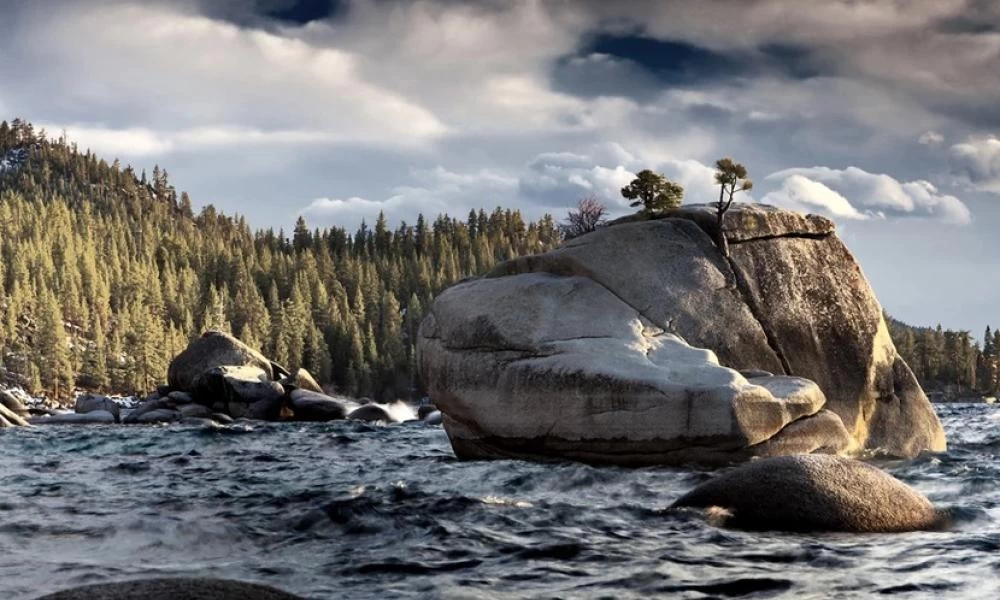 Το σκηνικό με το βράχο σε αλπική λίμνη όπου φύονται δέντρα